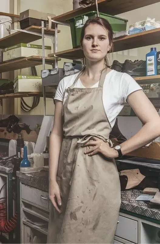 Eine Frau in Arbeitskleidung steht in einer Werkstatt